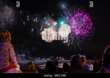 Barcelona, Spain: September 23, 2017: People are watching great fireworks at the coast of Barcelona, Spain during the La Mercè Festival, a large party all over the city to worship the patron saint La Mercè. Stock Photo