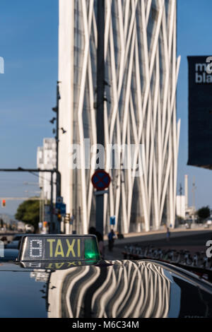 Barcelona, Spain - September 24, 2017: The skyscraper Diagonal Zero Zero and the Blue Museum of Natural Sciences (Museu Blau) are being reflected in the metal roof of a taxi. Both buildings are important architectural landmarks in Barcelona. Stock Photo