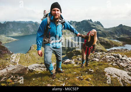 Happy Couple hiking in Norway mountains love and travel holding hands man and woman together Lifestyle concept vacations outdoor
