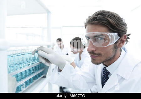 man in goggles to check fluid in vitro. Stock Photo