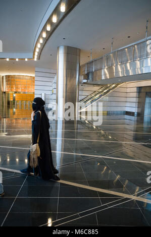 KUALA LUMPUR, MALAYSIA, inside the Mall / february 22, 2011: the entrance of the KLCC Mall is made of black marble and steel with a veiled woman Stock Photo