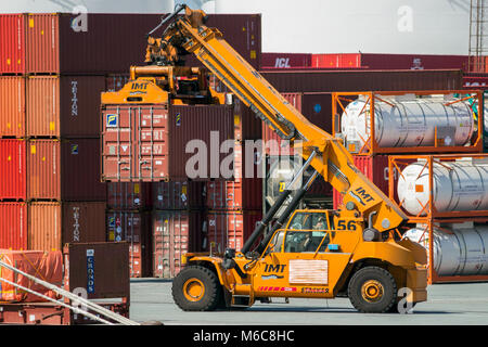 ANTWERP, BELGIUM - JUL 9, 2013: Reach stacker moving a cargo container in the Port of Antwerp. Stock Photo