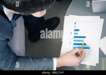 High angle view close up of businessman showing financial chart Stock Photo