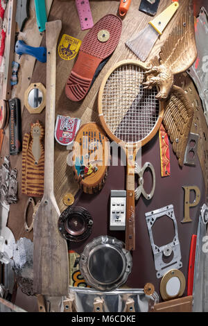 An art collage of home items arranged and stapled to a wall post. Stock Photo
