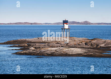 Traditional Norwegian steel lighthouse with solar battery and conical red top Stock Photo