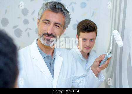 painter with apprentice and client Stock Photo