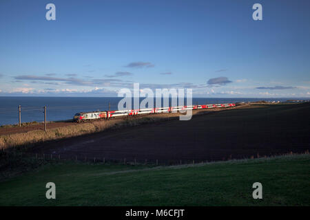 A Virgin trains east coast intercity 225 passes Marshall meadows, (north of Berwick upon Tweed) hauled by memorial liveried 91111 For the Fallen Stock Photo