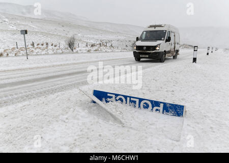 WEATHER PICTURE WALES Pictured: A van drives past a 'Police Slow' sign covered by snow at the side of the A470 road in Storey Arms, Brecon Beacons in  Stock Photo