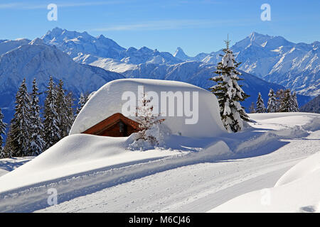 Deeply snow-covered mountain hut, in the back summit Dom 4545m, Matterhorn 4478m and Weisshorn 4505m, Riederalp, Aletsch area Stock Photo
