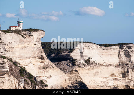 Corsica: the breathtaking white limestone cliffs in the International Bouches de Bonifacio marine park with view of the Cape Pertusato Lighthouse Stock Photo