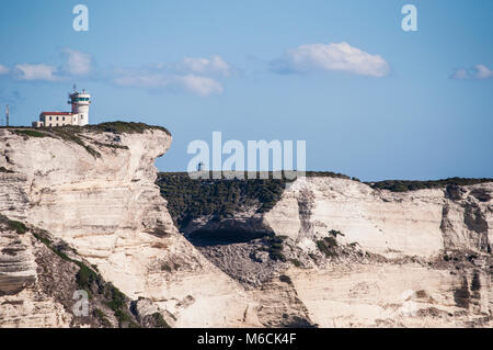 Corsica: the breathtaking white limestone cliffs in the International Bouches de Bonifacio marine park with view of the Cape Pertusato Lighthouse Stock Photo