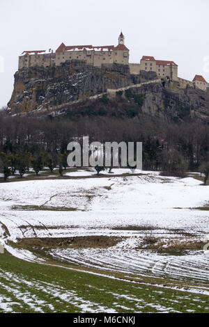 Vertical shot of the imposing Riegersburg castle perched on top of a sheer cliff on a winter day Stock Photo