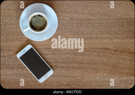 a cup of coffee and smartphone on the wooden background top view Stock Photo