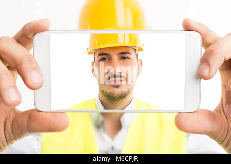 Constructor or builder taking a selfie with smartphone back hd camera confident and isolated on white background Stock Photo