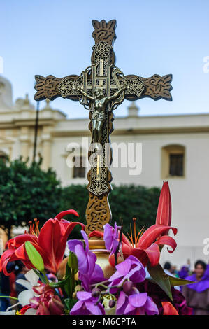 Antigua, Guatemala -  March 15, 2015: Crucifix & flowers during Lent in town with most famous Holy Week celebrations in Latin America Stock Photo