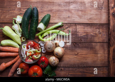 healthy fresh vegetarian salad in a bowl, fresh raw vegetables on background, top view. Stock Photo