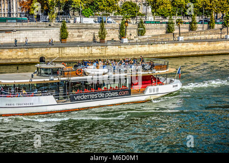 Tourists enjoy a sunny afternoon cruise on a boat on the Seine River in Paris France Stock Photo