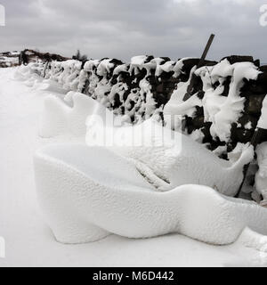 UK weather: Ilkley Moor, West Yorkshire, UK. 2nd March 2018.  Snow sculptures created by strong winds on the lee side of stone walls as the wind whistles through - Beast from the East.  Rebecca Cole/Ģ����ý Live News Stock Photo