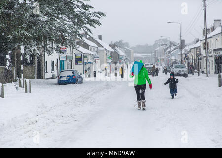 Celbridge, Kildare, Ireland. 02 Mar 2018: Main street in Celbridge covered in snow in the aftermath of the cold wave bugged 'The Beast from The East' followed by Storm Emma. People out walking on the covered in snow road in Celbridge town. Winter scenery. Stock Photo