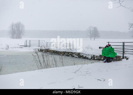 Celbridge, Kildare, Ireland. 02 Mar 2018: Man photographer with Canon equipment taking photos of covered in snow Castletown Park in Celbridge. Beast from the east followed by Storm Emma brought snow and high winds paralyzing the country   and forcing Met Éireann to issue the red warning alert across Ireland. Stock Photo