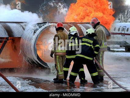 Members of the Slovakian Air Force, (in dark blue), learn how to put out major aircraft fires for the first time in the UK at the RAF Manston Defence Fire Training &amp; Development Centre in Ramsgate, Kent. Stock Photo