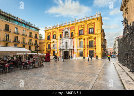 Malaga, Spain - December 7, 2016: Episcopal palace facade and tourist sitting on the restaurants terraces and walking around Bishop Square in Malaga c Stock Photo