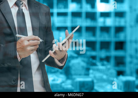 Businessman using the tablet on Abstract blurred photo of book store background, blue color tone Stock Photo