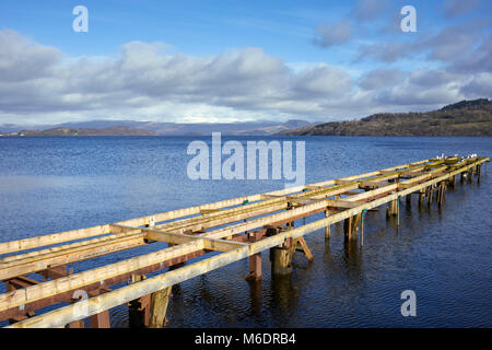 A bright, sunny and welcoming stop at Duck Bay on the shore of Loch Lomond. Northwards towards Inchmurrin and snowcapped Bein Uird and Ben Lomond Stock Photo