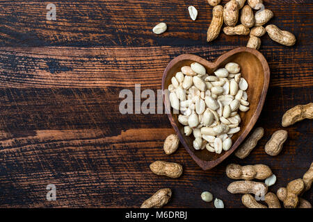 Peanuts snack in bowl on dark background. Stock Photo