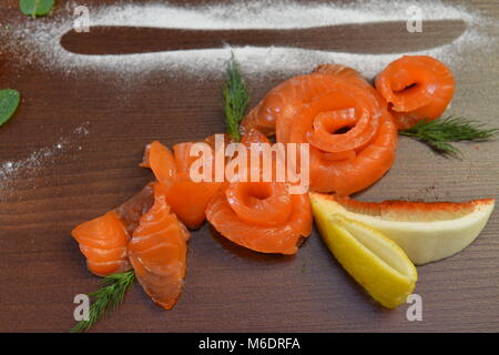 Sliced Smoked or Salty fresh Salmon with Lemon and Dill selective focus. restaurant food. Fish dish, banquet, catering served plate at rustic wood wit Stock Photo