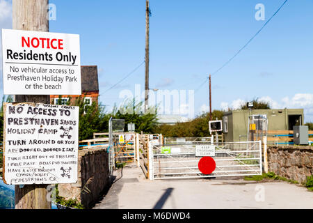 Amusing notice attached to wooden post ahead of a railway crossing addressed to tourists staying at Presthaven Sands holiday camp. “No Access To Prest Stock Photo