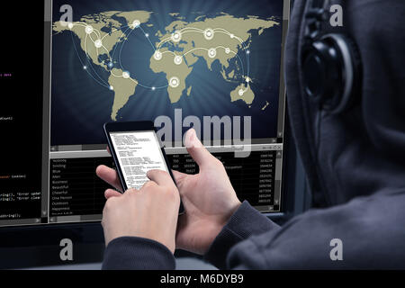 Hacker Using Mobile Phone For Stealing Data From Computer Screen Showing World Map Stock Photo