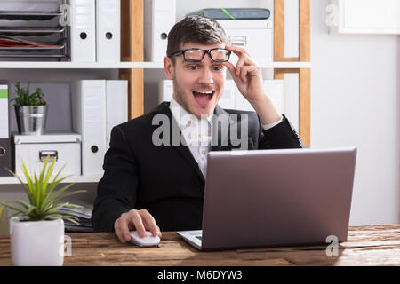 Excited Young Businessman Looking At Laptop In Office Stock Photo