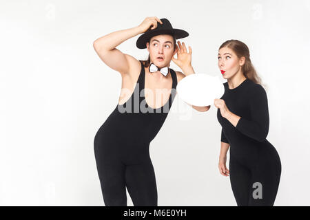 Young adult woman tells gossip in secret. Studio shot, isolated on white background Stock Photo
