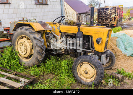 An old tractor designed for various works on an agricultural farm. An open cabin. Late autumn. Podlasie, Poland. Stock Photo