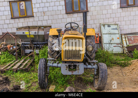 An old tractor designed for various works on an agricultural farm. An open cabin. Late autumn. Podlasie, Poland. Stock Photo