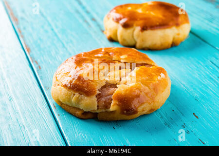 side view two sweet mini chewy cakes or chickee cakes on blue wood background Stock Photo