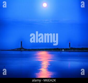 this is a view of the large moon over Thatcher Island that has the twin lighthouses. Stock Photo