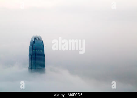 The foggy Hong Kong skyline. Many buildings are covered when viewed from the Peak. Only the tallest skyscrapers can have their upper part visible. Stock Photo