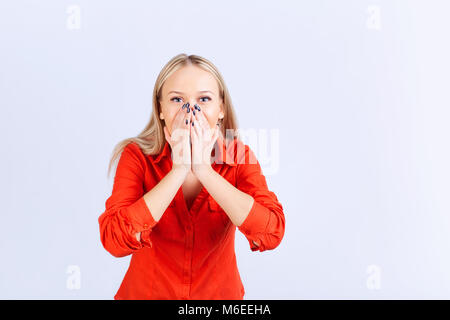 Blonde woman in casual clothes with a surprised emotion on a gray background. Stock Photo