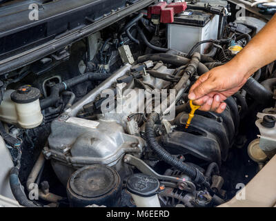 Hand of car mechanic working in auto repair service. He have fix old car engine streaked with dust and oil stains Stock Photo