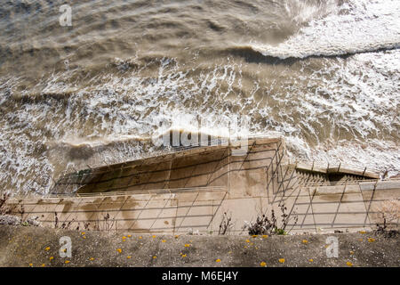 The high tide at Ramsgate lapping on the promenade steps to the sandy beach. Stock Photo