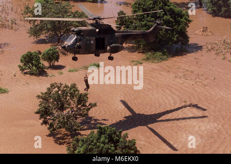 Floods in Mozambique, March 2000; A South African Air Force helicopter rescues stranded people from rooftops near Chibuto, Gaza Province. Stock Photo