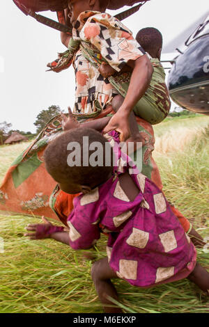 Floods in Mozambique, March 2000; Rescued people run to safety after a South African helicopter drops them on high ground  near Chibuto, Gaza Province. Stock Photo