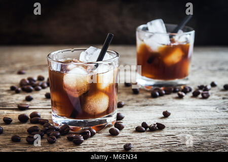 Black Russian Cocktail with Vodka and Coffee Liquor. Homemade Alcoholic Boozy Black Russian drink with coffee beans on wooden background with copy spa Stock Photo