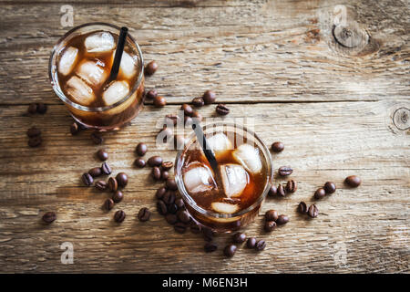 Black Russian Cocktail with Vodka and Coffee Liquor. Homemade Alcoholic Boozy Black Russian drink with coffee beans on wooden background. Stock Photo