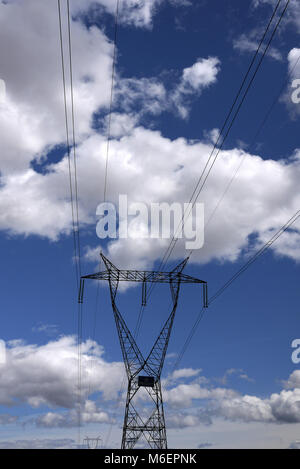 Power lines and pylon against a blue cloudy sky in Spain. Stock Photo