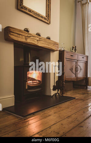 Cosy interior of victorian home with contemporary wood burning stove Stock Photo