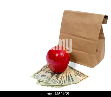 Horizontal shot of the back of a brown paper bag with the top folded down.  In front of this is a red shiny apple sitting on fanned out twenty and ten Stock Photo