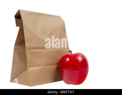 Horizontal shot of the back of a brown paper bag with the top folded down.  In front of this is a red shiny apple.  Isolated on white with copy space. Stock Photo